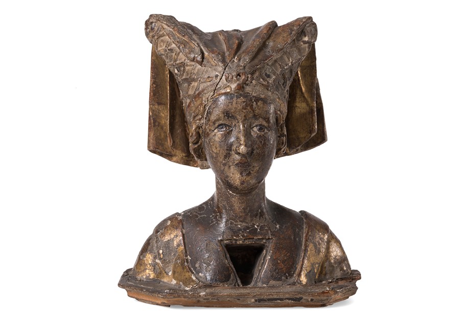 Image is a photograph showing a reliquary bust of a female saint wearing a divided hennin. It is made of wood.