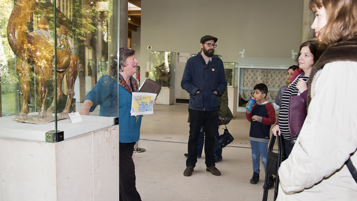 Volunteers standing inside the museum looking at an object