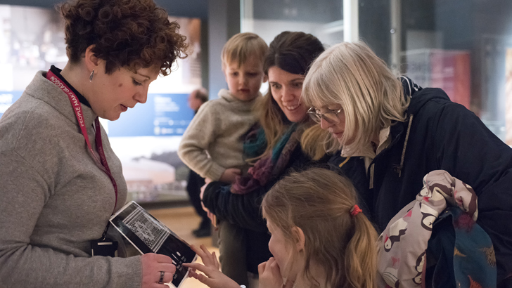 Museum staff showing a visitor group one of the displays