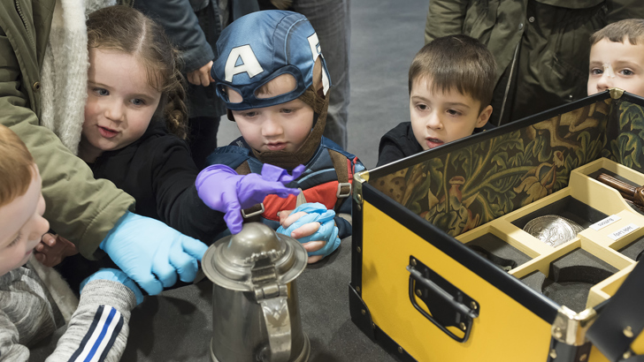 A group of small children interacting with objects from the Burrell Collection